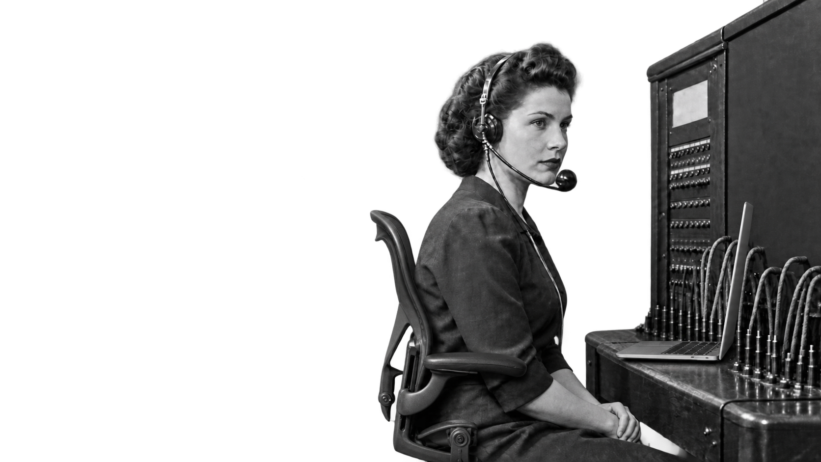 Switchboard operator wearing a headset beside a communications console